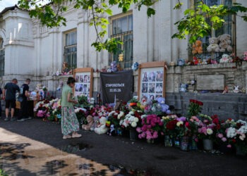Obyvatelia kladú kvety a hračky k improvizovanému pamätníku pri budove školy v Ruskom kontrolovanom Starobiľsku v Luhanskej oblasti, ktorú podľa ruských úradov poškodil ukrajinský dronový útok. Fotografia pripomína, že vojna proti Ukrajine si už vyžiadala státisíce obetí na oboch stranách frontu. FOTO: SITA/AP/Pavel Bednyakov