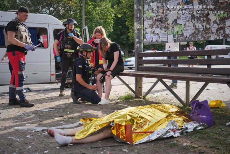 Záchranári ošetrujú zranenú ženu po dnešnom ruskom útoku v ukrajinskom Záporoží, po ktorom na zemi leží aj telo jednej z obetí. Útok prišiel krátko po tom, čo Vladimir Putin odmietol návrh Volodymyra Zelenského na osobné stretnutie a ukončenie vojny. Rusko namiesto rokovaní pokračovalo v ďalších dronových a raketových útokoch na Ukrajinu. FOTO: SITA/Ivan Fedorov via AP