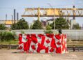 Před ocelárnou ArcelorMittal Dofasco v Hamiltonu stojí rozvodná skříň pokrytá kanadskými vlajkami. Foto: ČTK / AP / Nick Iwanyshyn