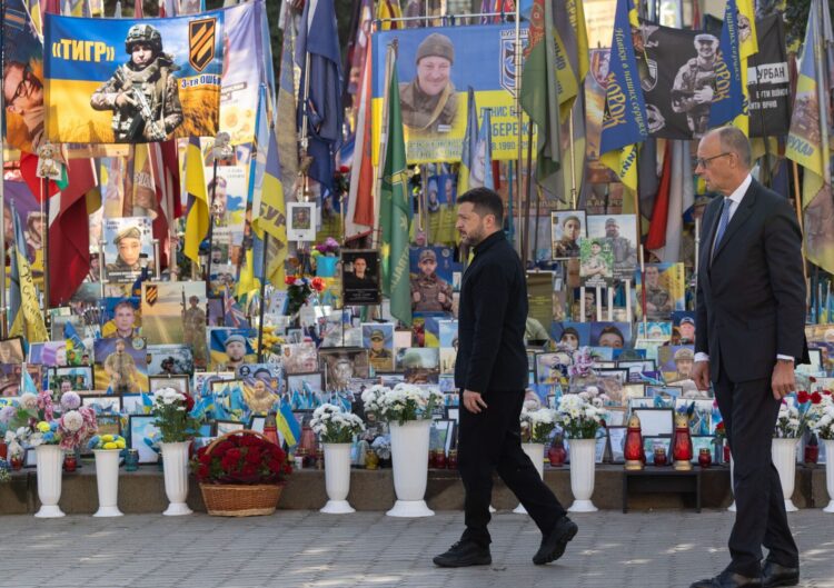 Prezident Ukrajiny Volodymyr Zelenskyj a nemecký kancelár Friedrich Merz vzdávajú úctu pri pamätníku obetí ruskej agresie na Ukrajine. Foto: SITA/AP